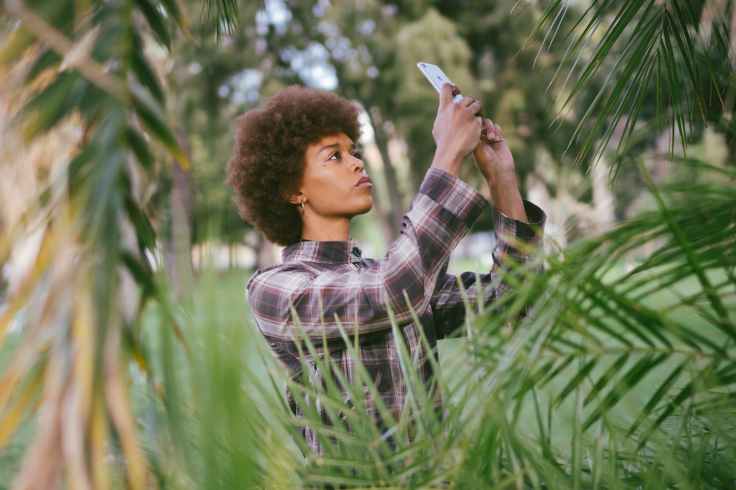 photo of woman taking picture of plants